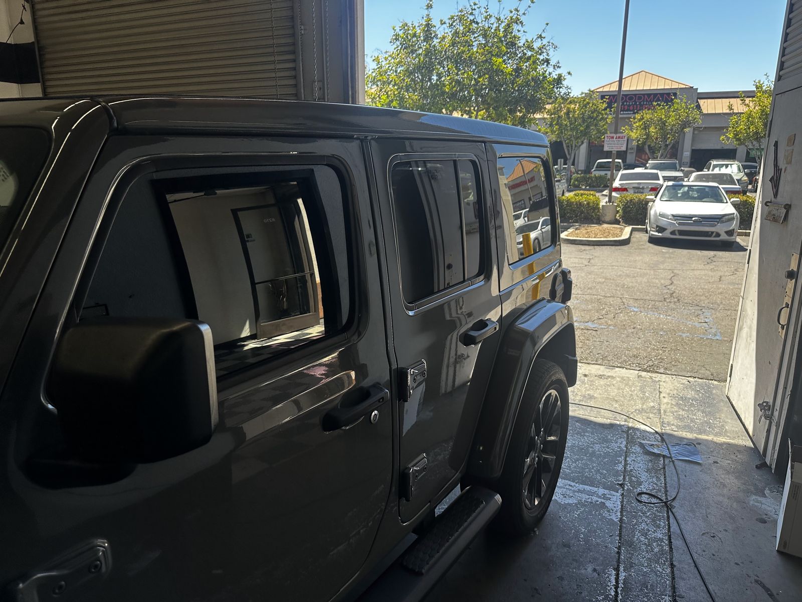 Dark Jeep Wrangler with tinted windows at the shop